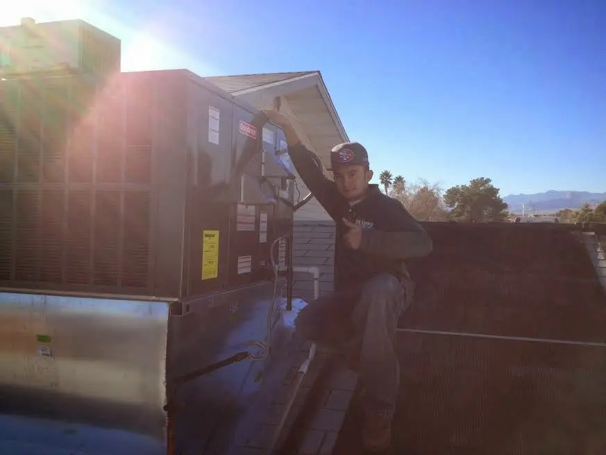 HVAC technician performing AC Tune-Up on a rooftop unit in Grayson Valley